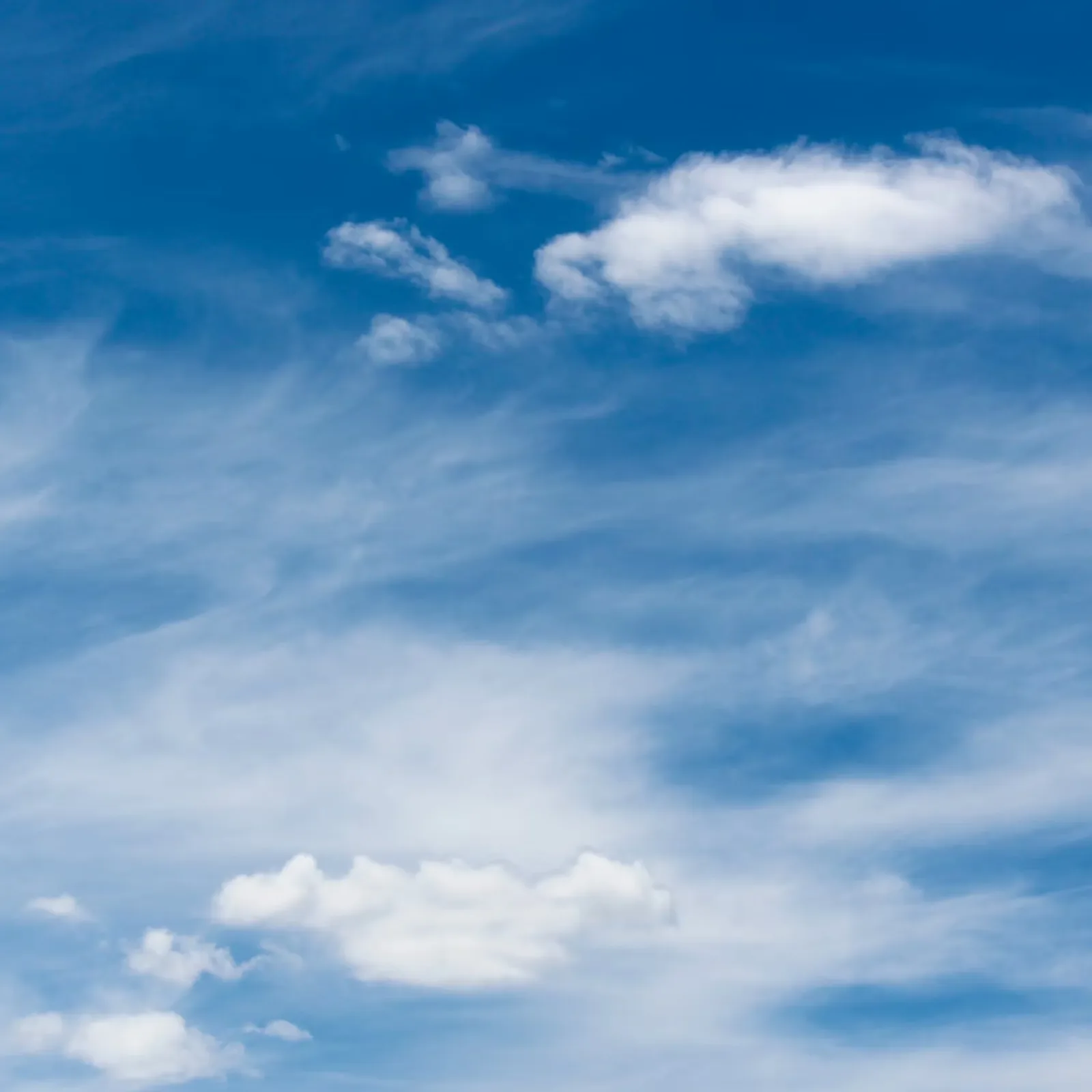 Wispy white clouds in a bright blue sky