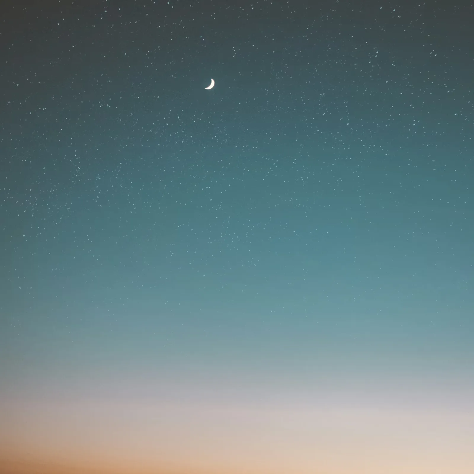 A crescent moon and stars in a deep blue twilight sky