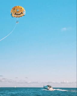 Kite flying over the ocean with a boat on the water