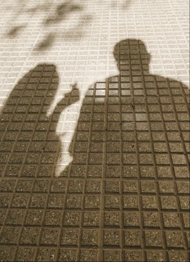 Silhouettes of two people cast in shadow on a gridded surface